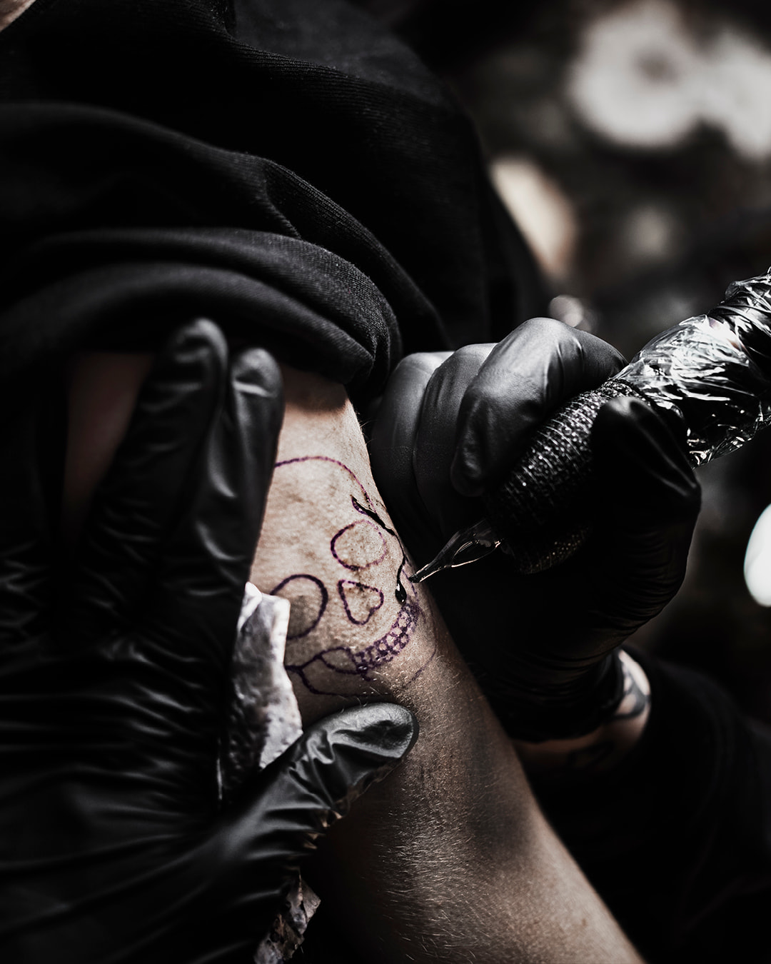 En person blir tatuerad med en dödsskalle