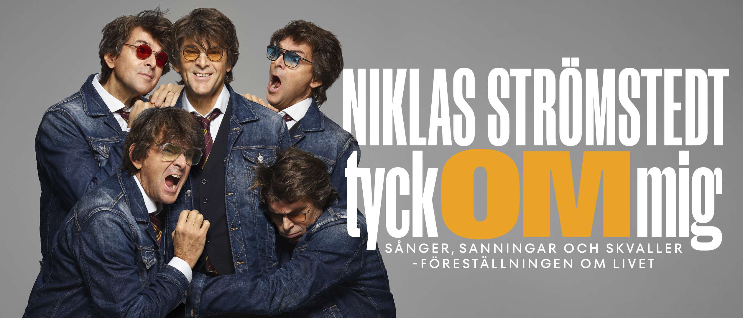 Niklas Strömstedt som fem personer. De är klädda i jeansjackor står och sitter tätt tillsammans mot en ljus bakgrund.