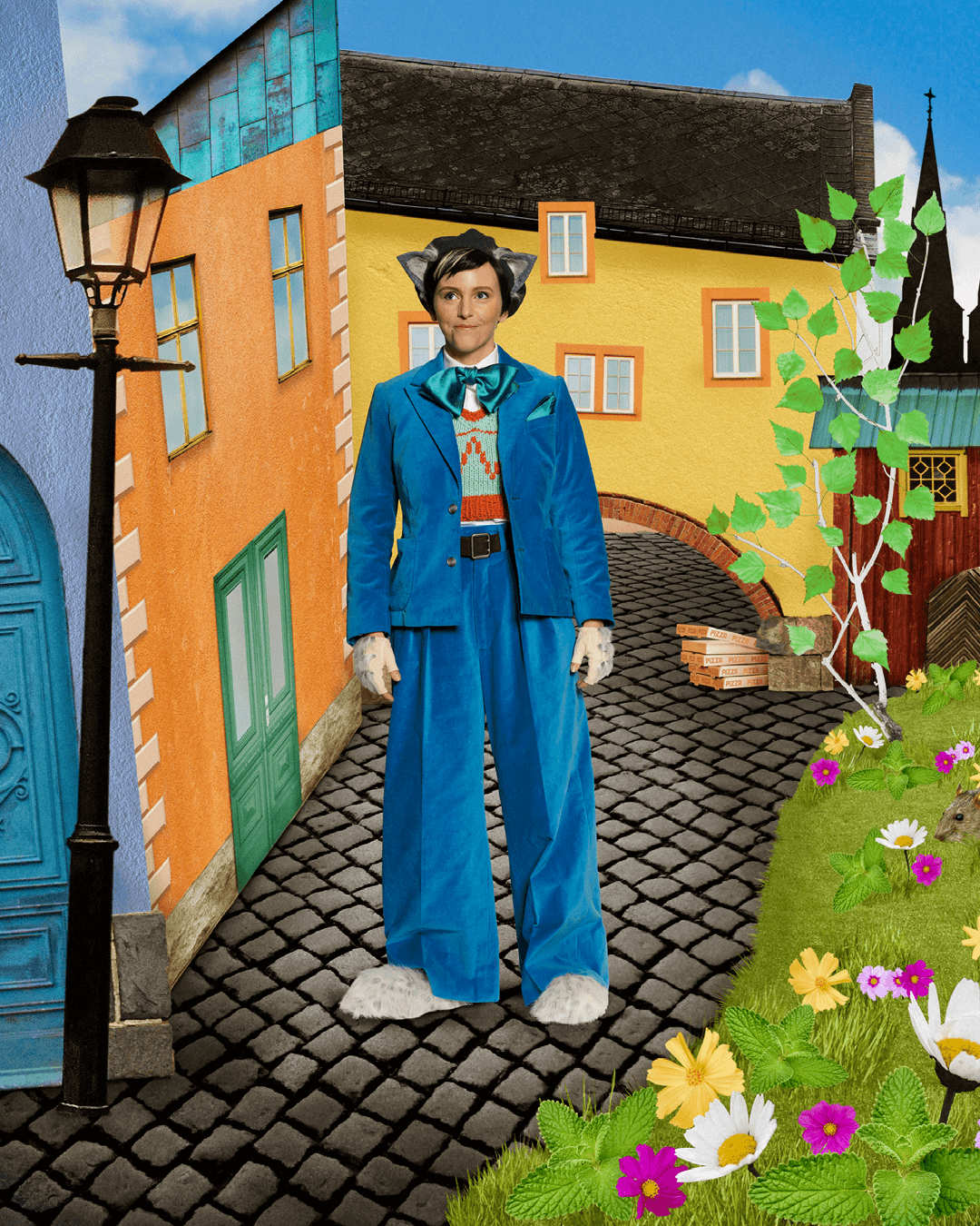 Skådespelaren Sonia Haga som Pelle Svanslös, klädd i blå kostym står på en kullerstensgata i ett fiktivt Uppsala, bland färgglada hus och blommor.
