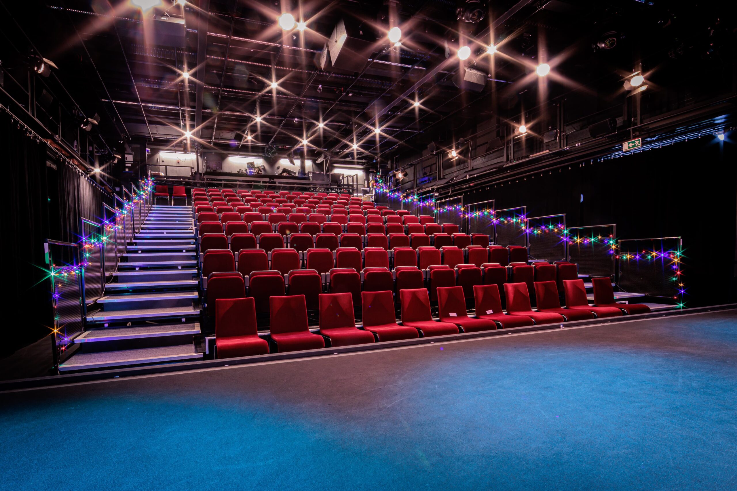 Amos-scenen är en mindre teatersalong med röda gradängsittplatser, låg scen och ett svart scenrum.