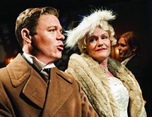 Patrick Henriksen talar med Helle Willberg i en scen ur pjäsen Esplanaden. Hellen har päls och en fjunig hatt. Patrick ikävll en tjock ljusbrun kappa med brett slag.