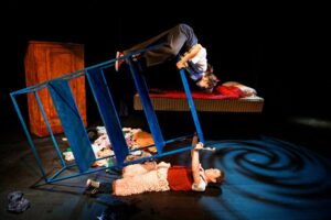 Två skådespelare klättrar på en omkullvänd stege