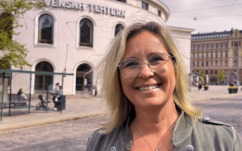 Porträtt framför Svenska Teatern i Helsingfors av den nyanställda chefen för extern finansiering och partnerskap.